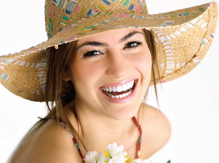 Image of woman smiling with beautiful teeth featured on our discount program brochure.